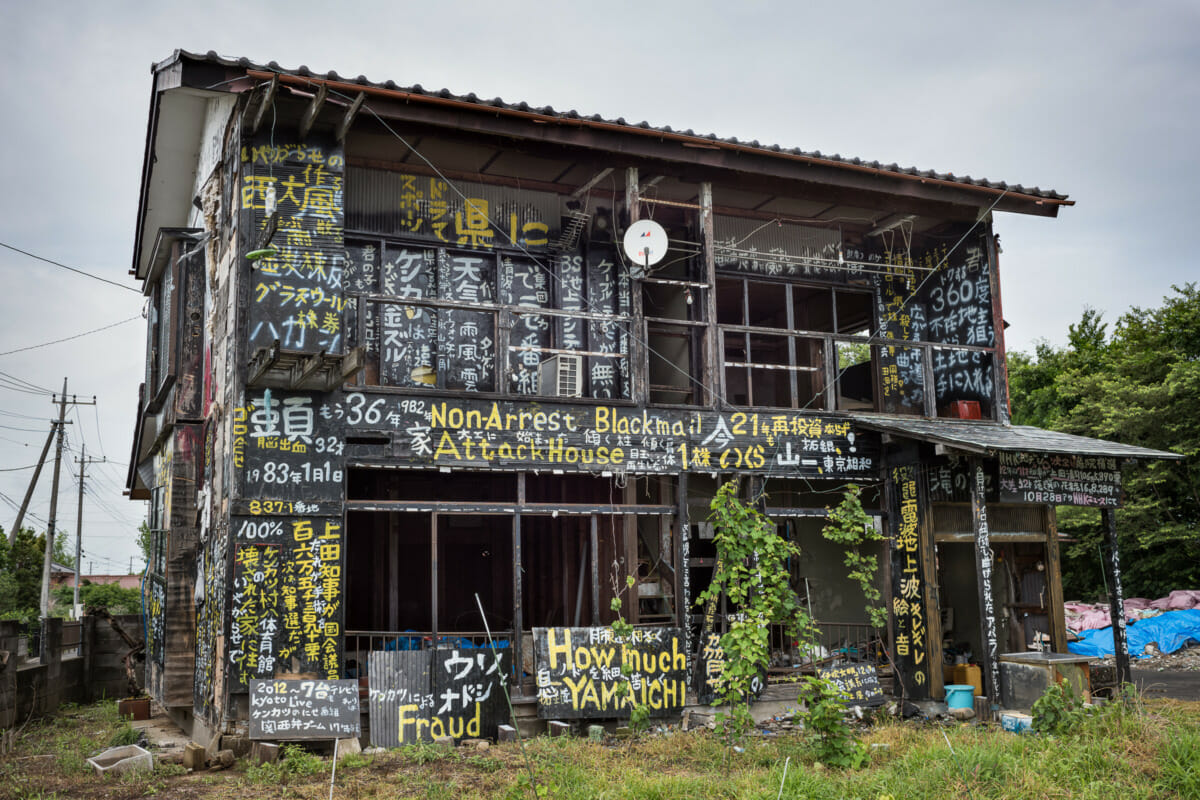 a dilapidated and kanji daubed Japanese house