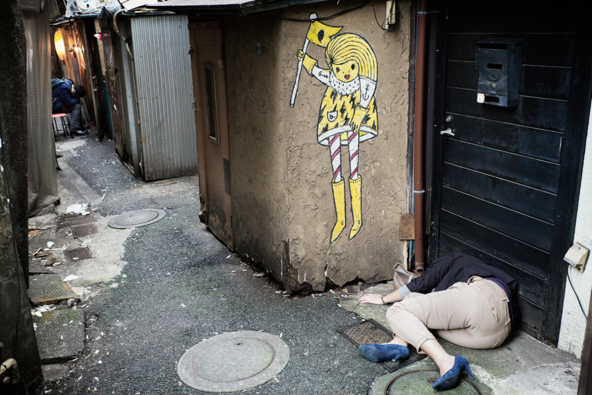 Japanese woman passed out drunk in a dirty Tokyo alleyway