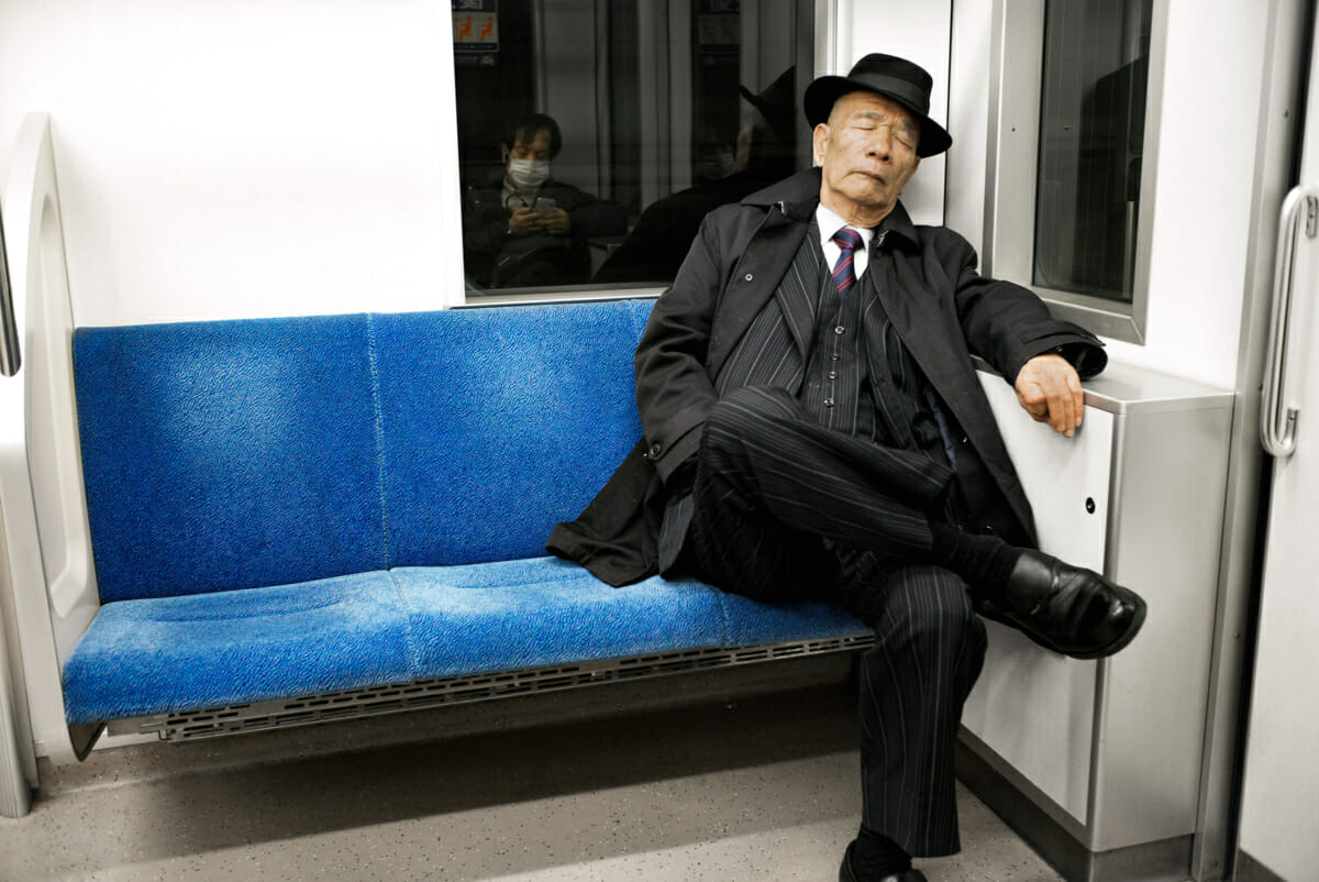 old school tokyo train traveller in pinstripes and trilby