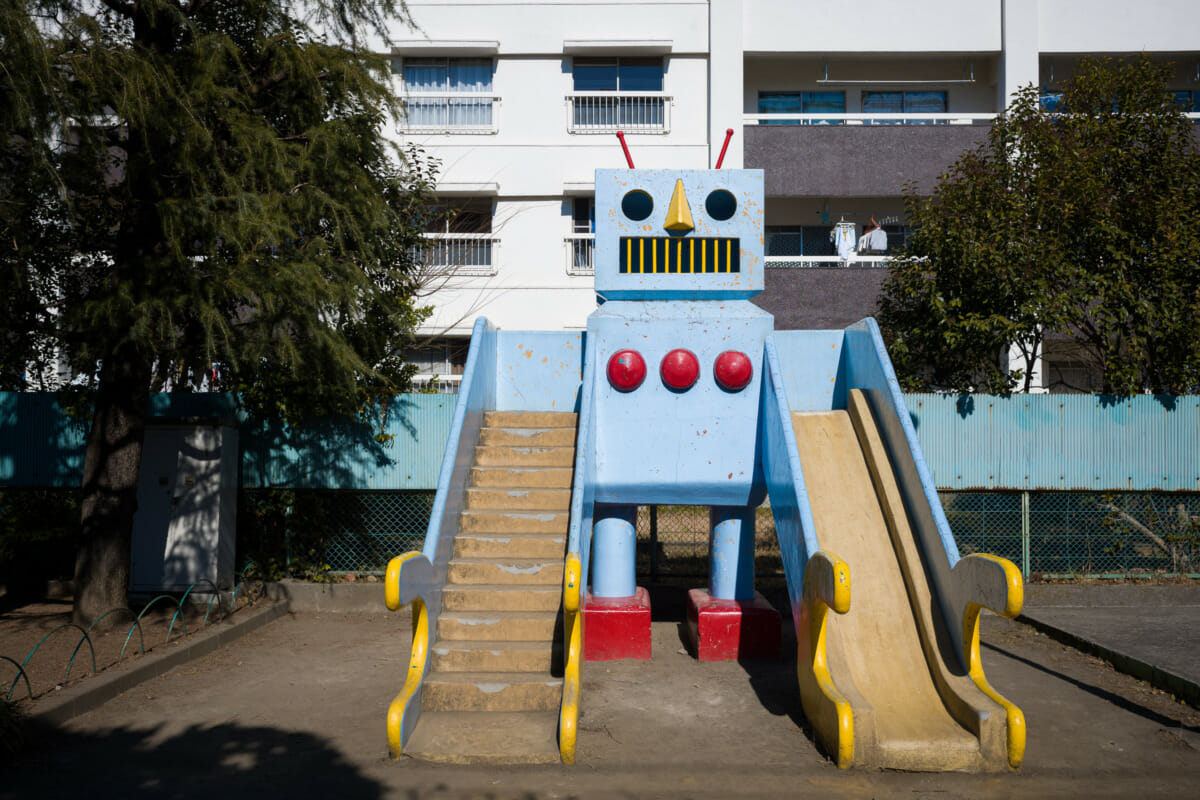 A large and retro concrete robot in an urban Tokyo park