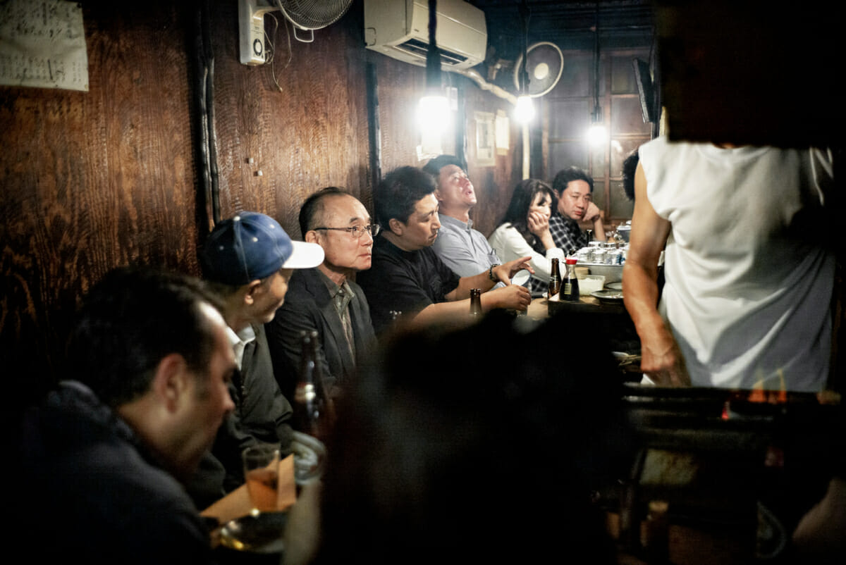 unhappy Japanese drinkers in a small Tokyo bar